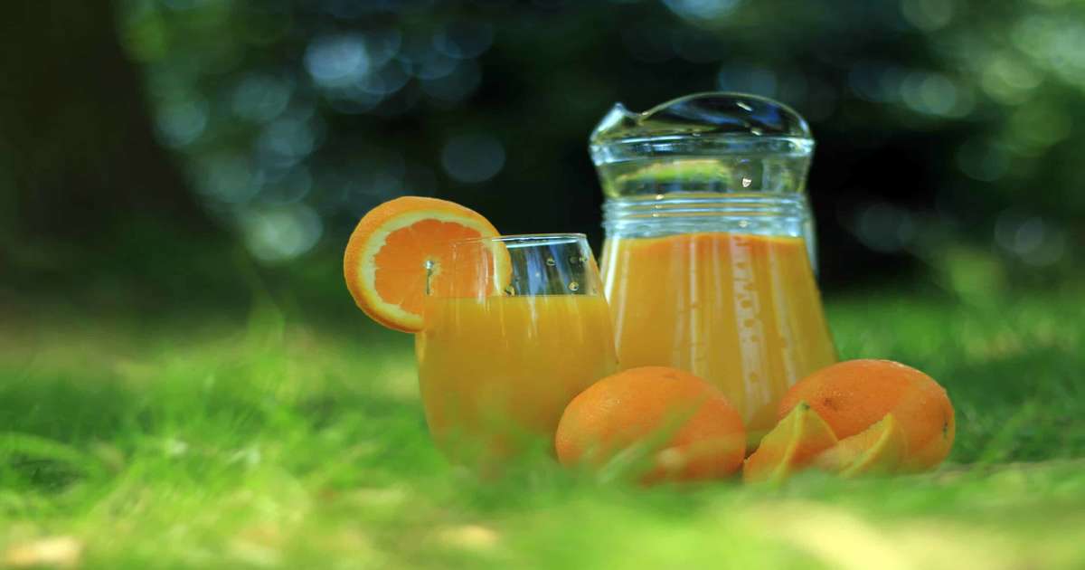 Two oranges and two glasses of orange juice.